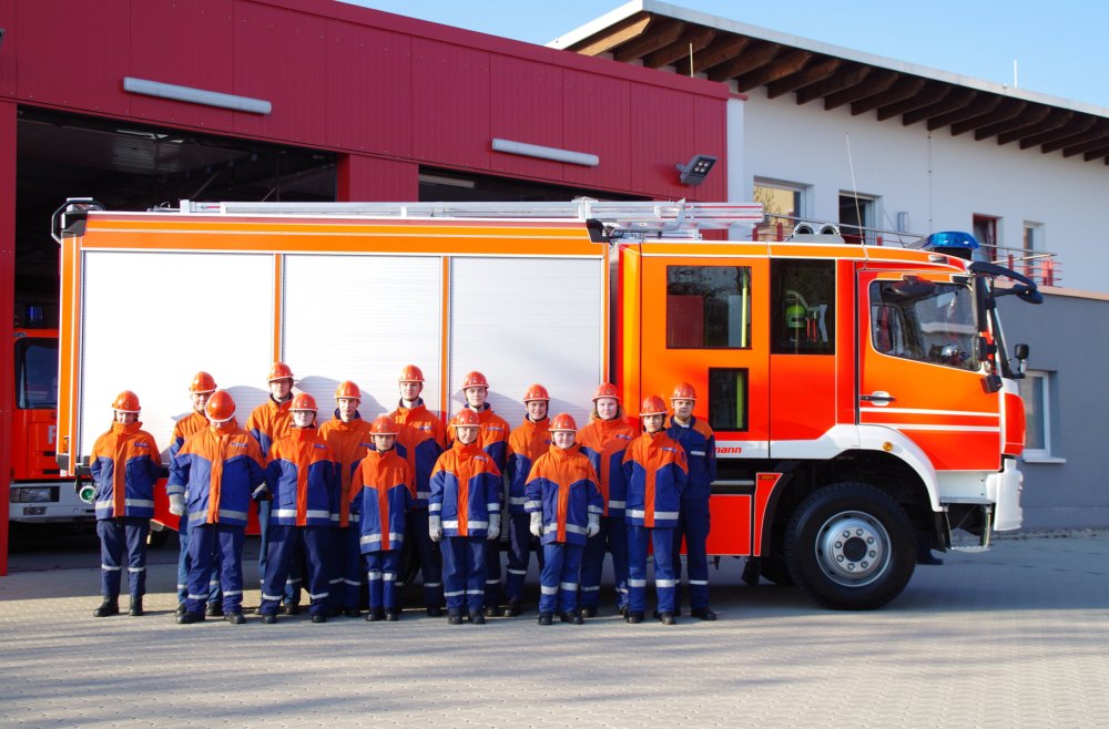 Die Kameradinnen und Kameraden der Jugendfeuerwehr Lüttringhausen in Uniform vor einem Löschfahrzeug.